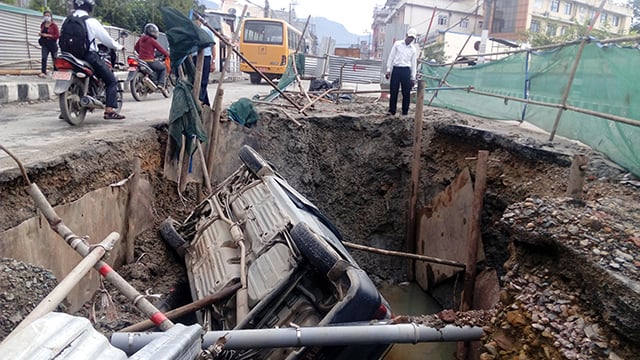A car falls into a sink-hole in Maharajganj, Kathmandu on Wednesday. Melamchi water mains have created such sink-holes throughout the city, where three construction workers fell to death last month.