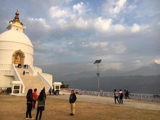 Visitors at the Peace Stupa in Pokhara on Friday morning to watch the sun rise over the partially covered Annapurnas.
