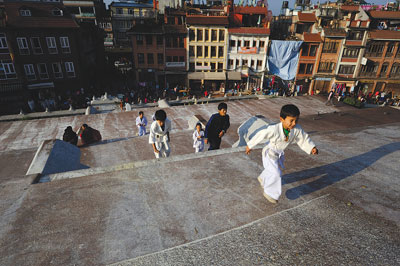 KARATE KIDS: Children run up and down the stairs leading to Boudhanath stupa early in the morning.