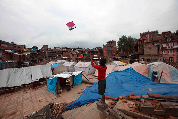 11-year-old Sushan Ghemosu flies a kite at the periphery of a temporary shelter at Lakulachhen in Bhaktapur on Tuesday.