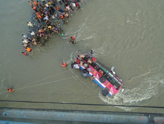 RESCUE MISSION : Locals, police and army personnel rescuing passengers of the bus that plunged into the Madi river in Tanahun on Saturday killing eleven people.