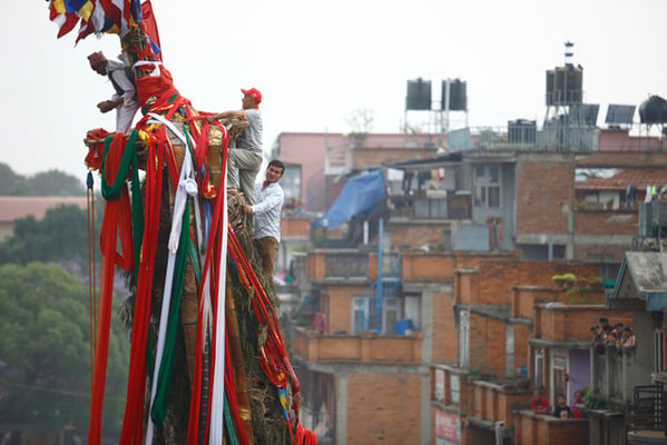 A priest holds a coconut before he throws it from the top of Rato Machindranath as part of the rituals during the chariot festival in Lagankhel on Monday.