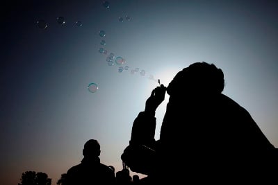 GONE WITH THE WIND: A street vendor attracts customers making soap bubbles with they toy he sells, in Tundhikel on Wednesday.