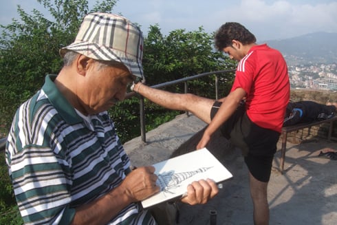 GOOD MORNING: An artist draws while another man goes through his exercise routine at Swayambhunath on Monday morning.