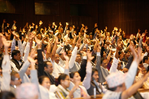 Lawmakers raise hands to endorse articles on the new constitution at the Constituent Assembly on Sunday. They endorsed the first three articles.