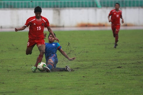TOUGH GAME: Nepal’s Bikash Thapa (red) in action against India in the 2nd SAFF U-16 Championship final at Dashrath Stadium on Tuesday. Nepal lost 1-0 to India.