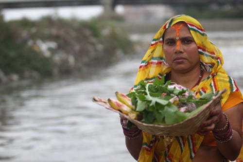 A woman performs a ritual to thank the sun on the occasion of Chhath Parba at Thapathali on Wednesday.