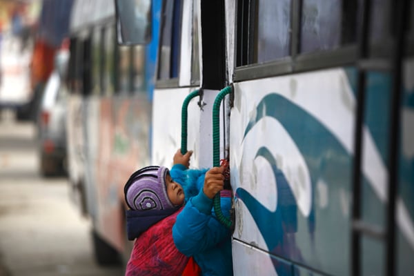A child dozes off to sleep as her mother gets inside a bus in Kalanki on Thursday.