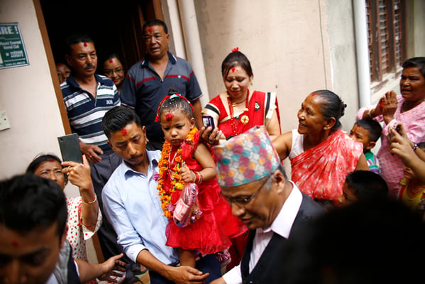 Three-year-old Trishna Shakya, newly appointed Kumari, aka living goddess is carried by her father from their private residence as they head towards the Kumari house in Kathmandu on Thursday.