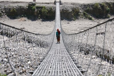 LONG WAY: A woman walks along a hanging bridge across the Seti river at Kharapani, Pokhara on Wednesday.