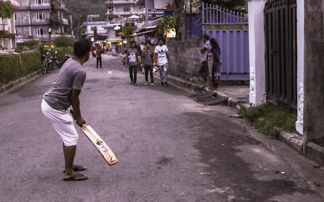 Locals play cricket in the streets of Lakeside, Pokhara on Friday.