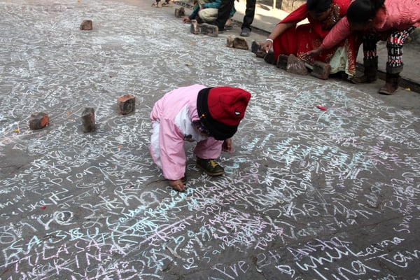 MIGHTY PEN: A child writing on the floor of Baglamukhi temple on the occasion of Saraswati Puja on Tuesday.