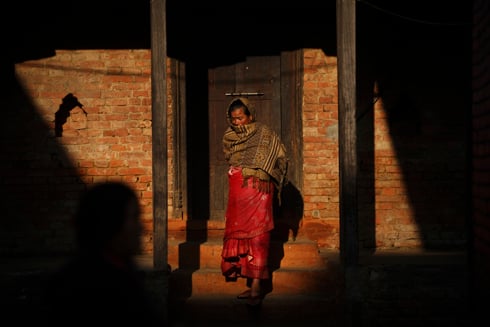 HERE COMES THE SUN: A woman stands in the morning sun at Khokana on Tuesday.