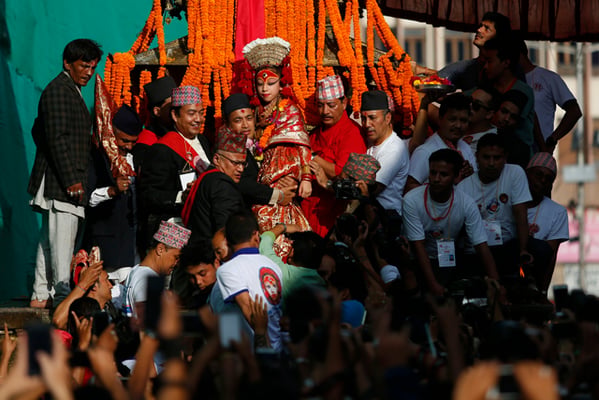 A devotee carries the living goddess, locally known as Kumari, to a chariot during the week-long Indra Jatra festival in Kathmandu on Thursday.