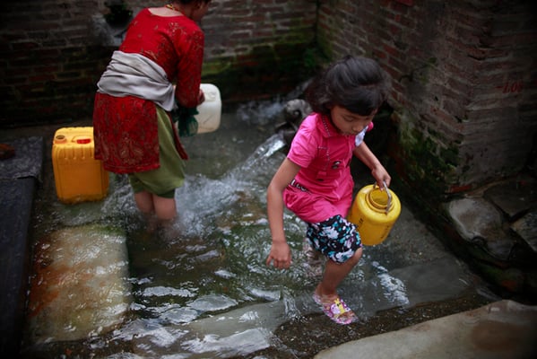 A little girl fetches water from a waterspout in Chyasal on Tuesday. Residents in the Valley have gained some respite as the monsoon has revived many stone waterspouts.