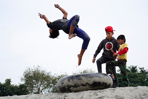 LIKE THIS: A boy shows his friends how to do a somersault along the banks of the Narayani river in Chitwan on Thursday.