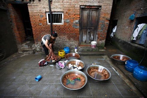 SEPARATE COLOURS: A woman does her laundry at the small yard below her house in Mangal Bazar on Monday.
