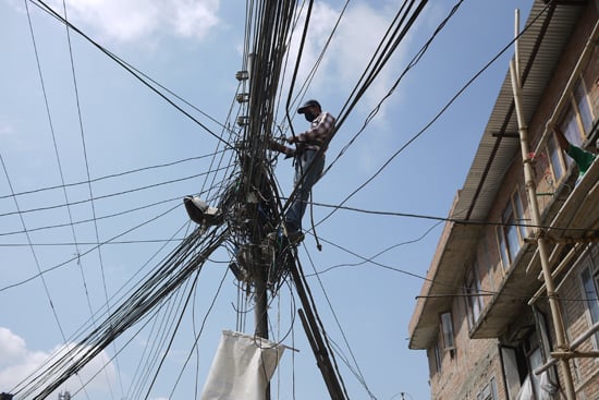 A man tries to untangle a cluster of power wires in Sanepa on Monday.