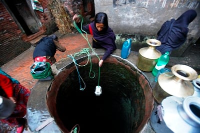 WISHING WELL: Women fill plastic jerry cans from the local water well to later refill the big traditional gagri, in Bhaktapur on Sunday.