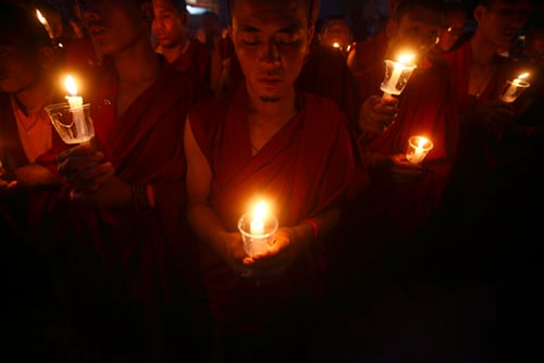 Buddhist monks hold a candlelight vigil in memory of the 25 April earthquake victims in Boudha, Kathmandu on Friday.