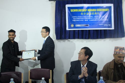 Unnat Sapkota (left) and Nisha Kunwar (not seen in the photo) studying journalism at Kathmandu University receive scholarship from China Daily at an event in Kathmandu Sunday.