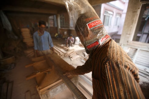 HOLD YOUR BREATH: Carpenters work on the doors and windows of a newly built house in Indrachok on Thursday.