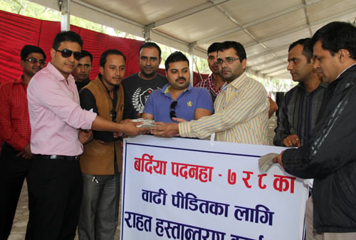 Narayan Poudel of Bardiya receiving Rs. 417861 in relief fund from Lion's club members and other organisations to help the victims of the Bardiya flood on Wednesday.