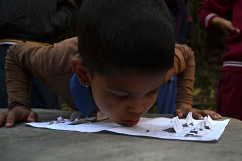 HOLD YOUR BREATH: Eight-year-old Aman Maharjan guides the ball in a game of blow football near Gausala. He wins 10 wrestling cards if he scores.