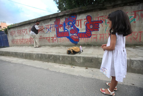 COLOR KATHMANDU: An artist paints mural over political slogans in Kupondole on Saturday afternoon.