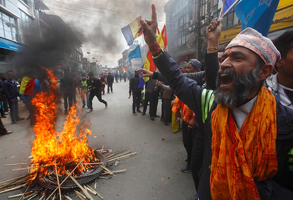 RPP party activists shout slogans and burn tires on Monday in protest of the Election Commission's decision to remove 'monarchy' and 'Hindu kingdom' from the party's statute.
