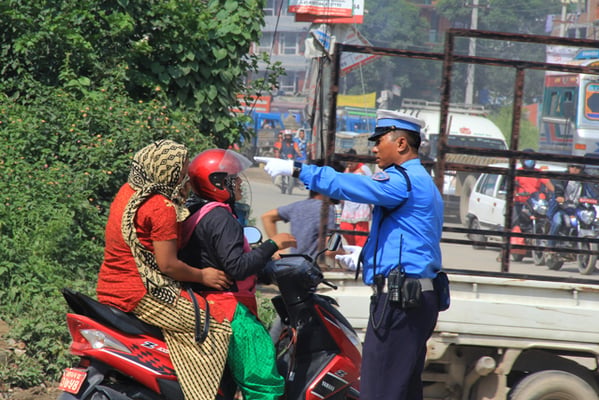 A traffic police stops a scooter for violating a rule at Satdobato chowk on Monday.