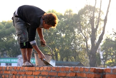 ANOTHER BRICK IN THE WALL: A teenager spreads cement to build a wall at Jawalakhel on Monday.