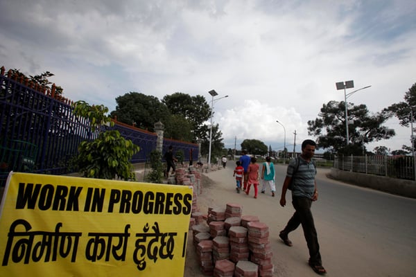A man walks beside an under construction sidewalk during the first day of Nepal bandh at Sundhara on Sunday.