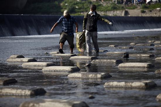People collect garbage from the Bagmati River during the Bagmati Clean-up Campaign in Thapathali on Saturday.