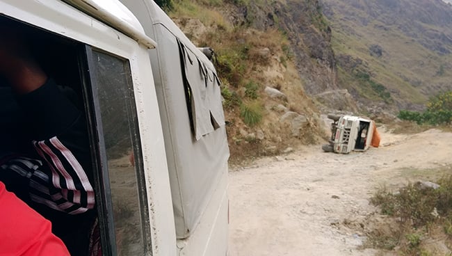 An upturned jeep lies beside the road on the way from Manang to Besisahar on Thursday.