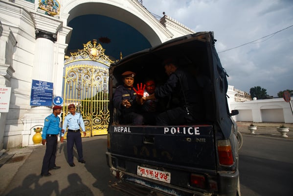 Nepal Police detains protesters for smearing red powder on the western wall of Singha Darbar in Kathmandu on Thursday.