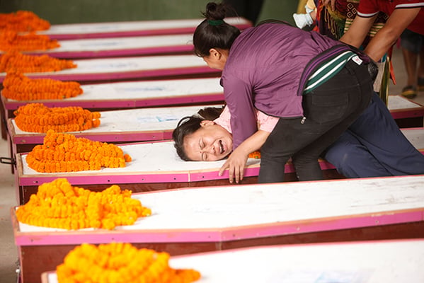 Relative weeps over the coffin of one of the 12 Nepalis killed in Kabul flown home Wednesday.