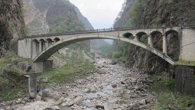 BORDERLINE: The bridge over the Bhote Kosi, and below it the remains of the old one washed away in 1981. A new hydropower plant under construction above.