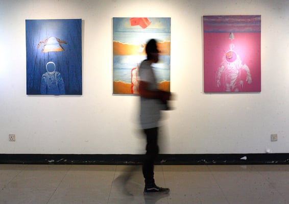 A visitor walks by the paintings at artist Saroj Bajracharya's exhibition titled 'The Missing Link' being held at Park Gallery, Lalitpur on Wednesday.