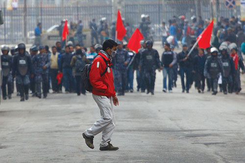THE WALL: A man walks by as members of UML-affiliated student union take out a rally at Exhibition Road on Tuesday demanding the government to punish the murderers of journalist Dekendra Thapa.