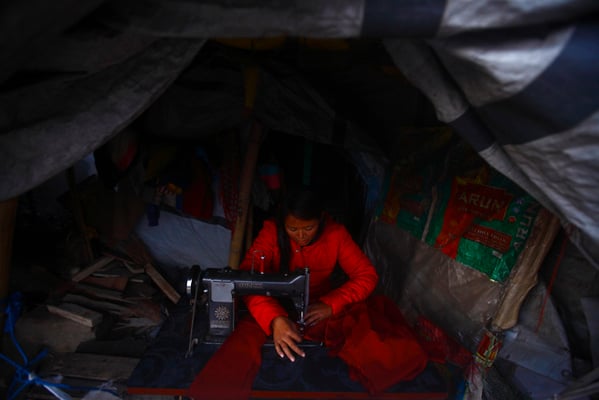 28-year-old Bipana Tamang sews clothes in a temporary shelter at Chuchepati on Sunday. After the earthquake, she has continued her work as a tailor in the shelter which has helped support her livelihood.