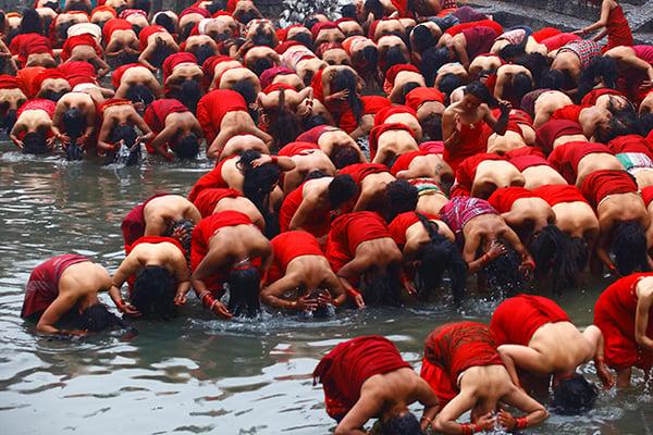 Devotees take a holy bath during the Swasthani Brata Katha festival at Pashupatinath Temple on Monday.