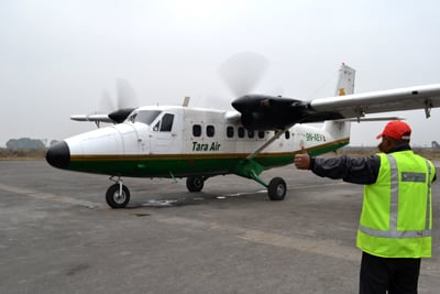 JET, SET, GO: An airline staff at Nepalganj Airport gives the go ahead for Tara Air's flight to Bajura on Tuesday morning.