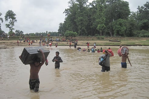 Travellers wade across the Paruwa Sota river in Banke after a bridge over it on the East-West highway collapsed after heavy flooding from incessant rains in the Mid-West.