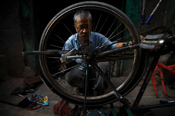 A mechanic repairs an old bicycle in Bhotahiti, Kathmandu. As fuel shortage caused by an unofficial Indian blockade deepens, more people are now seen riding bicycles.