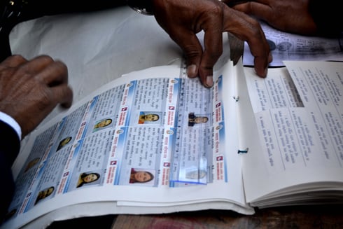 LISTEN UP: An Election Commission officer about to distribute voter ID cards in Kaushaltar on Friday.