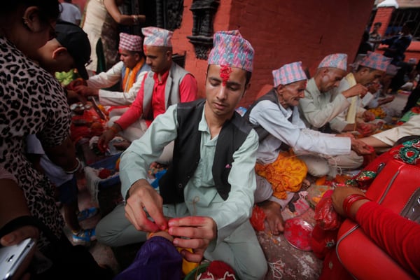 Hindu priests tie sacred threads around the wrists of people on the occasion of Janai Purnima (Raksha Bhandan) at Bagalamukhi temple, Lalitpur on Saturday.