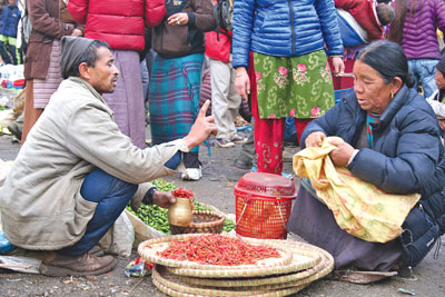 NO DISCOUNT: A woman bargains with a street vendor in Lukla for the price of chilies.