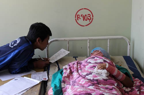 Acid attack victim Sangita Magar takes her SLC exams with the help of an assistant at K.M.C. hospital on Thursday.
