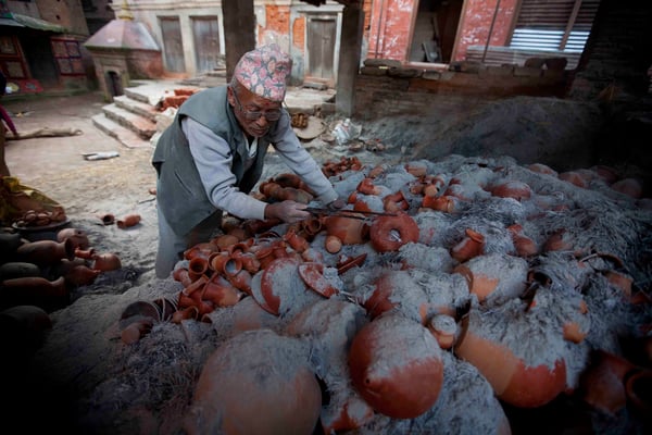 A potter in Bhaktapur inspects his clay products after firing them on Monday.